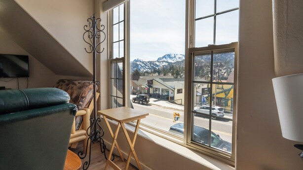 Una habitación con vista a una calle y montañas.