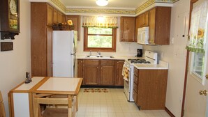 Eine Küche mit Holzausstattung, einem Kühlschrank, einem Herd und einer Spüle.