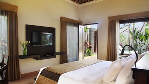 Habitación de hotel con una cama, un televisor montado en la pared, vistas al exterior y una puerta que da a un balcón.