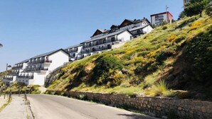 A hillside residential area with modern houses featuring balconies and a stone retaining wall. - Bellevue by Interhome (Sierra Nevada)