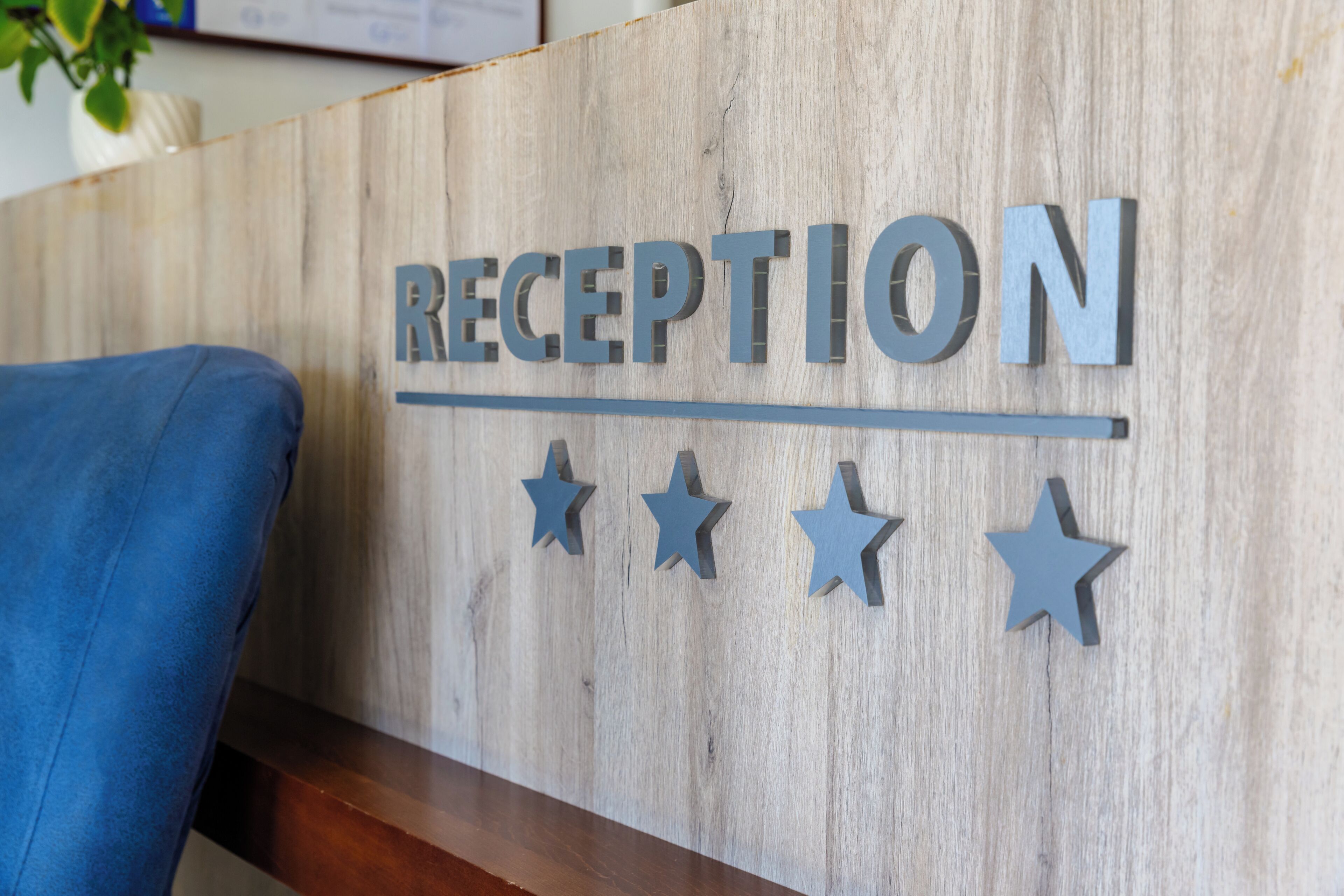 Un mostrador de recepción de madera con la palabra "RECEPTION" y tres estrellas encima.