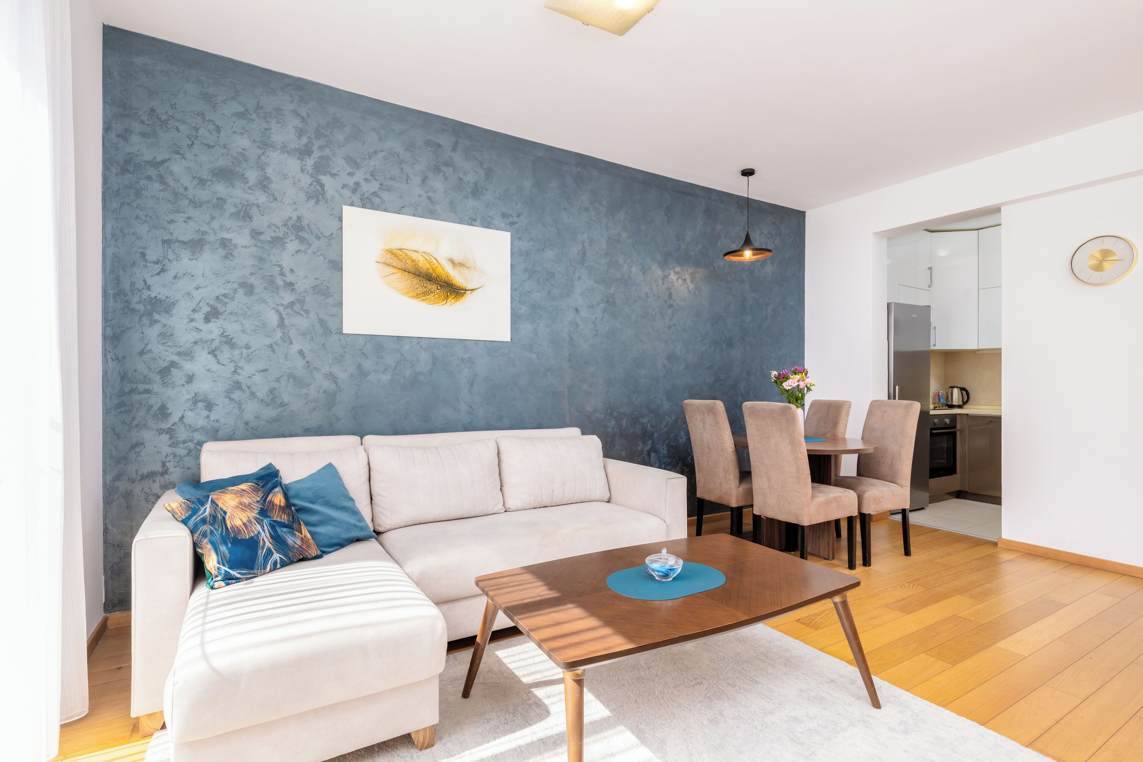 A modern living room with a sofa, coffee table, and dining area.