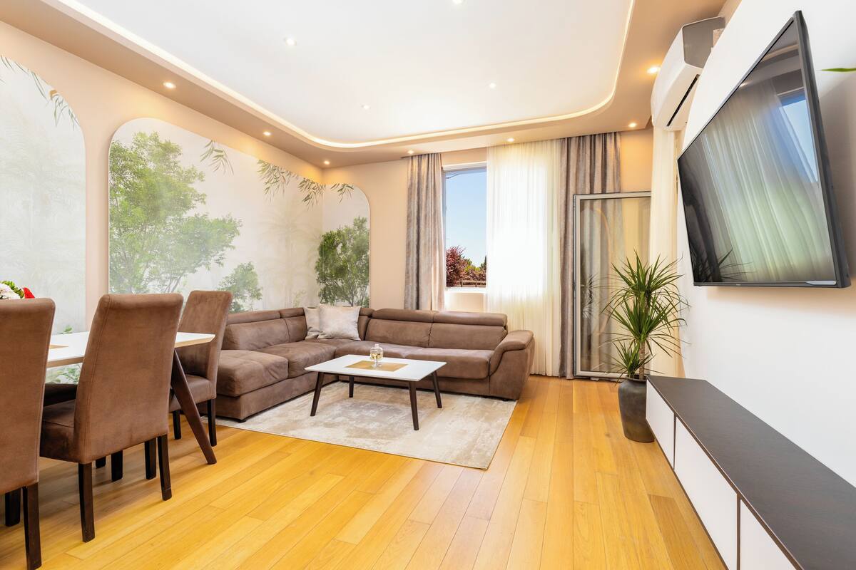 Ein modernes Wohnzimmer mit Sofa, Couchtisch und Essbereich.