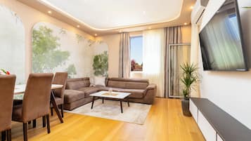 Apartamento conforto, 2 quartos | Área de estar | Smart TV 125 cm com canais a cabo
