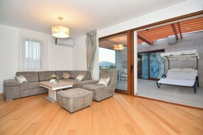 Apartamento luxo, 2 quartos, banheira de hidromassagem, vista para o mar | Área de estar | Smart TV 125 cm com canais a cabo