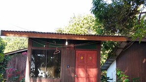 A small, single-story building with a red door and a balcony. - Johan's Place (Tioman Island)