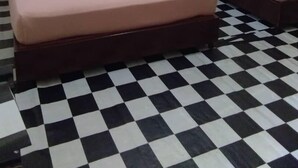 A hotel room with two beds, a checkered floor, and a window with curtains. - Johan's Place (Tioman Island)