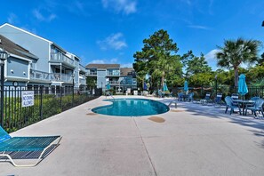 Enjoy a refreshing swim in the pool surrounded by lounge chairs and umbrellas.