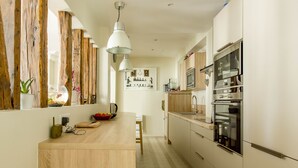 A modern kitchen with wooden accents, stainless steel appliances, and a central island.