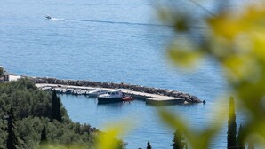 A marina with boats docked, a pier, and a rocky shoreline.