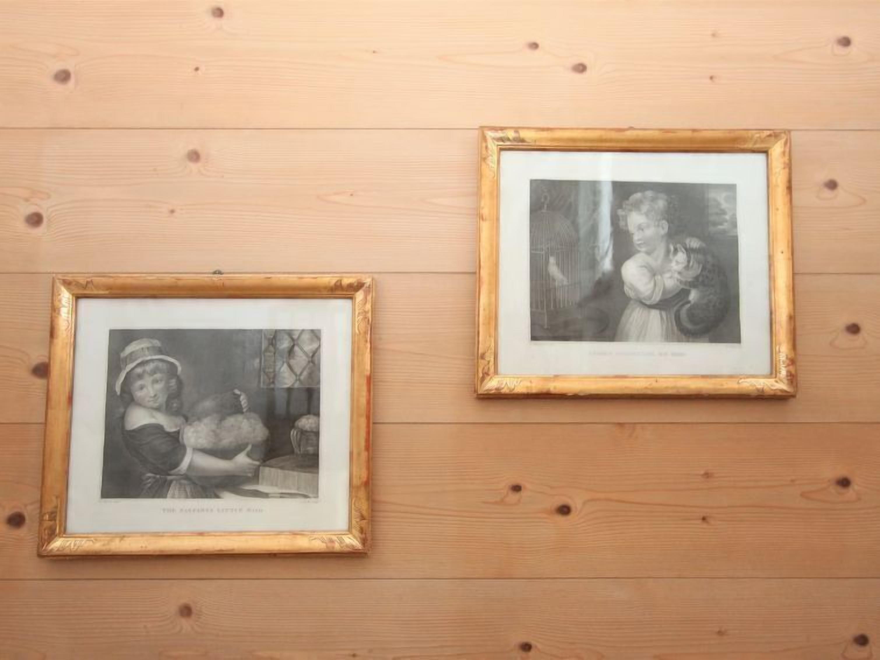 Two framed black and white photographs on a wooden wall.