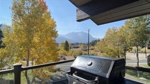Una griglia barbecue su una terrazza esterna con vista su alberi e montagne.