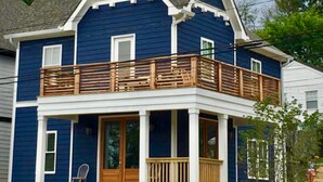 A two-story house with a balcony and a front porch.
