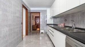 A modern kitchen with a black countertop, stainless steel sink, and white cabinets. - Home2Book Spacious Classic Design Apto SC Center (Santa Cruz de Tenerife)