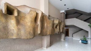 A modern interior with a unique rock-like wall feature, a staircase, and a clean, polished floor. - Home2Book Spacious Classic Design Apto SC Center (Santa Cruz de Tenerife)