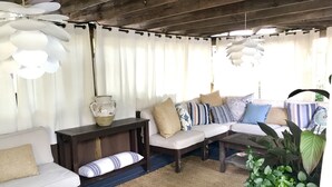 Ein gemütliches Wohnzimmer mit einem weißen Sofa, einem Holztisch und einem gemusterten Teppich.