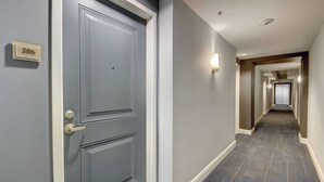 A hallway with a grey door labeled "206" and a carpeted floor. - One bedroom in amazing luxury condo. BEACH PASS INCLUDED! (Boynton Beach)