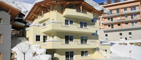 A multi-story hotel with balconies and a snow-covered landscape.
