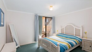 A bedroom with a bed, a nightstand, a chair, and a view through a window with curtains. - Horizons 1 - Location, location, location! (Forster)