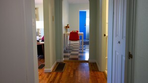 A hallway with a checkered floor leading to a room with a blue door. - Art Inspired Cottage just 1 block from Main Street (Trinidad)