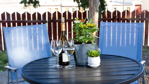 A round metal table with two wine glasses, a bottle, and a small potted plant. - Art Inspired Cottage just 1 block from Main Street (Trinidad)