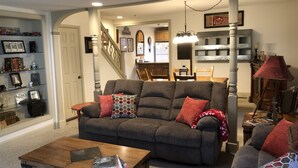 A living room with a sofa, coffee table, and a bookshelf.