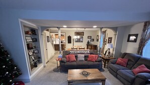 A living room with a sofa, a coffee table, and a Christmas tree.
