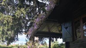 A wooden house with a covered porch, a small garden, and a car parked nearby. - Very nice 'villetta' in beautiful and quiet fully garden. (Bardolino)