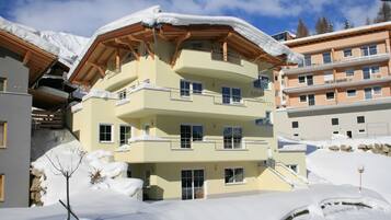 Ein mehrstöckiges Hotel mit Balkonen und einer verschneiten Landschaft.