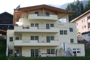 Ein mehrstöckiges Gebäude mit Balkonen, einem Schild mit der Aufschrift "APART LA VITA" und einer Treppe, die zum Eingang führt.