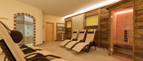 Un espacio de spa con sillones reclinables, una pequeña recepción y una pared de madera con ventanal.