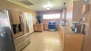 A kitchen with a refrigerator, stove, microwave, and sink.