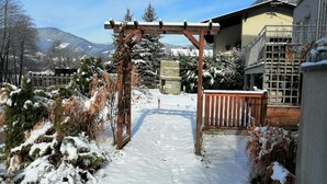 A snow-covered pathway leading to a wooden pergola in a residential area with a mountain backdrop. - 140 m² apartment surrounded by nature (Puchberg am Schneeberg)