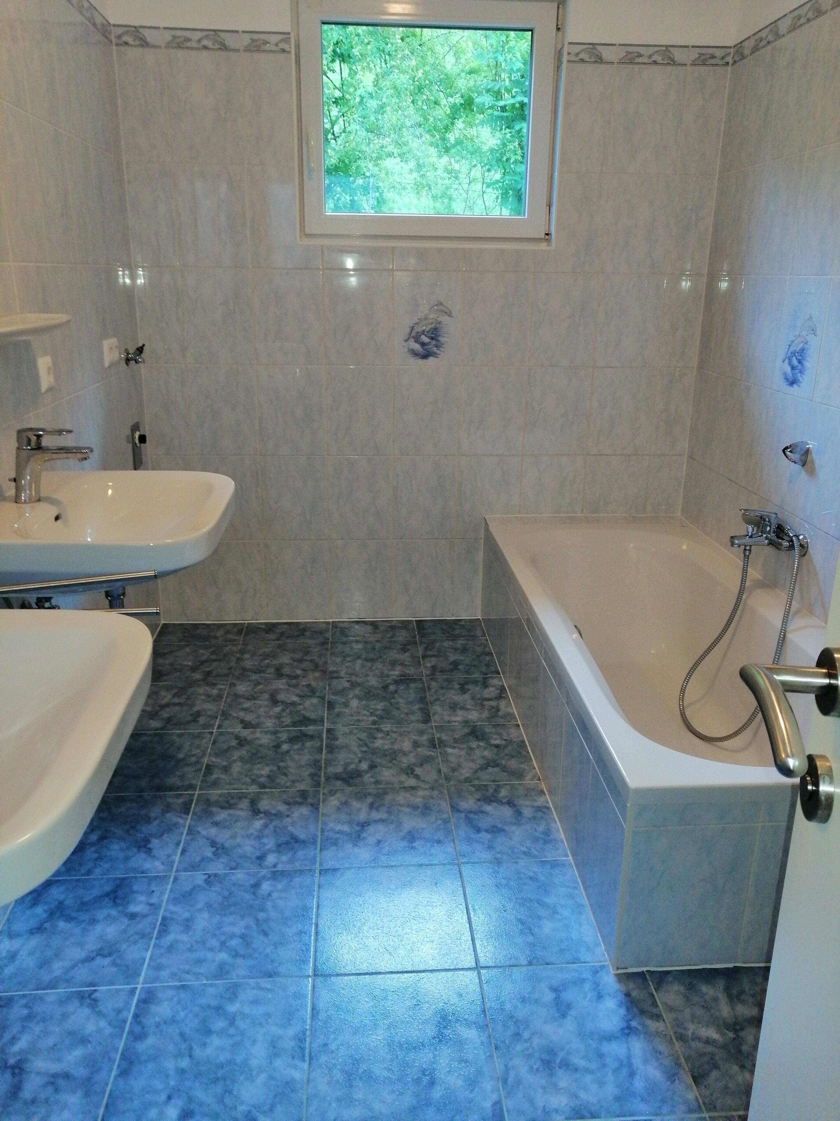 Un baño con bañera, lavamanos y ventana.