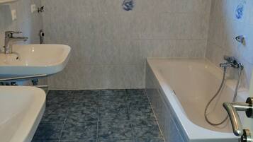 Un baño con bañera, lavamanos y ventana.