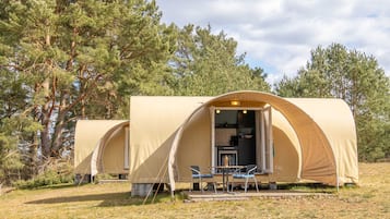 Una carpa de dos ambientes con comedor y kitchenette.