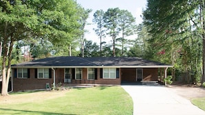 A two-story brick house with a front porch, a driveway, and a lawn. - About Legacy House @ Concord (Smyrna)