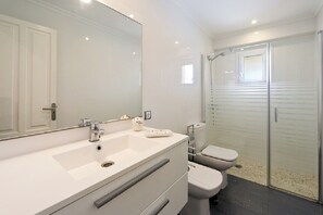 Een douche, een haardroger, een bidet, handdoeken