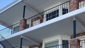 Een meerlaags woongebouw met bakstenen gevels, witte details en zwarte balustrades.