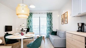Una cocina moderna con comedor, sofá y televisor.