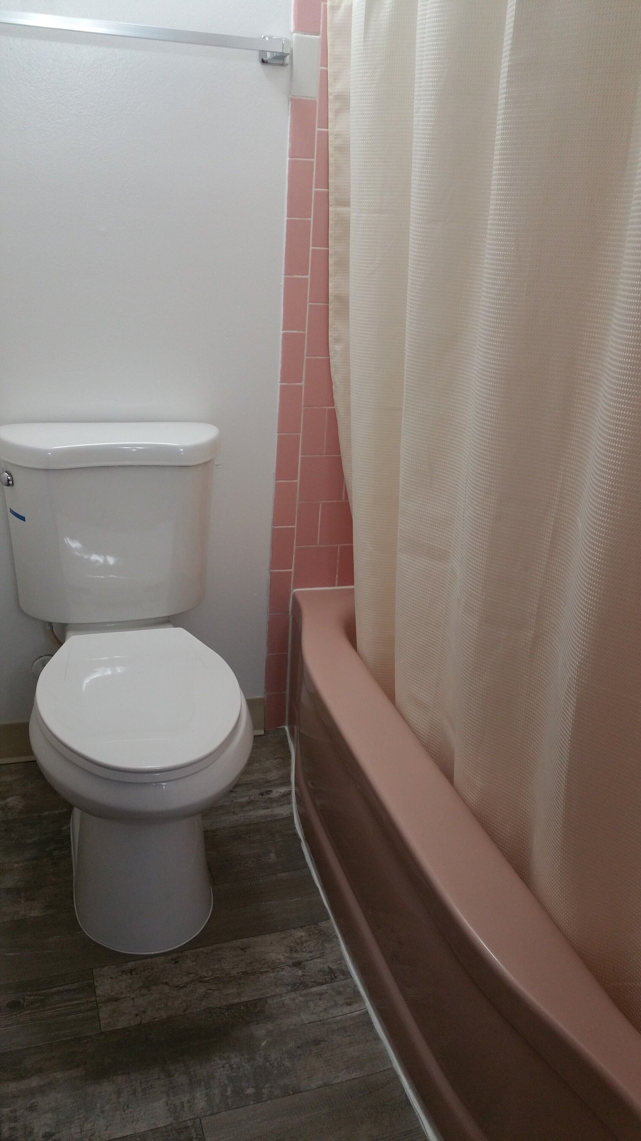 Une salle de bain avec des toilettes, un rideau de douche et une baignoire.