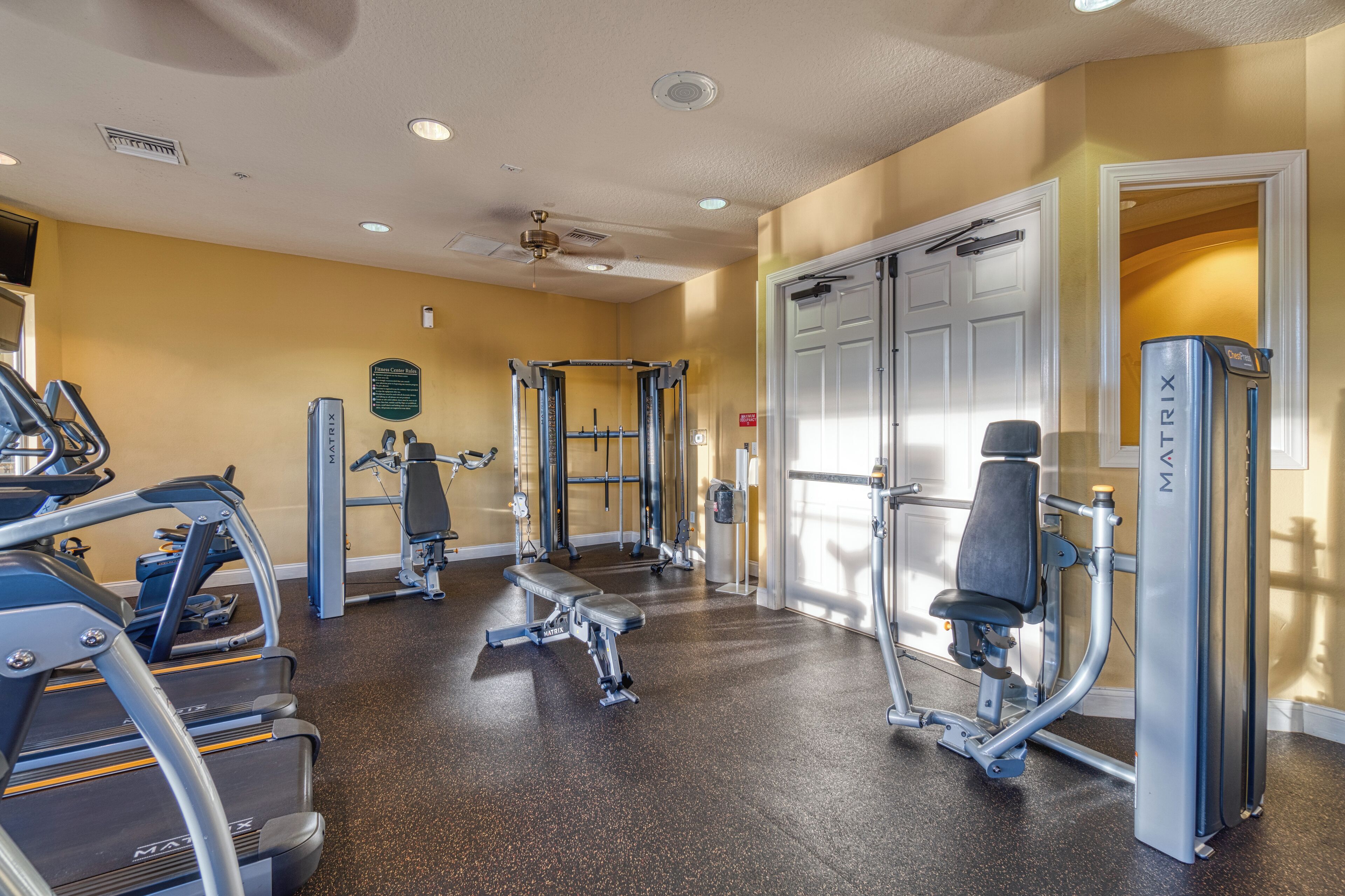 A gym with treadmills, weight machines, and a bench.