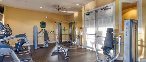 A gym with treadmills, weight machines, and a bench.