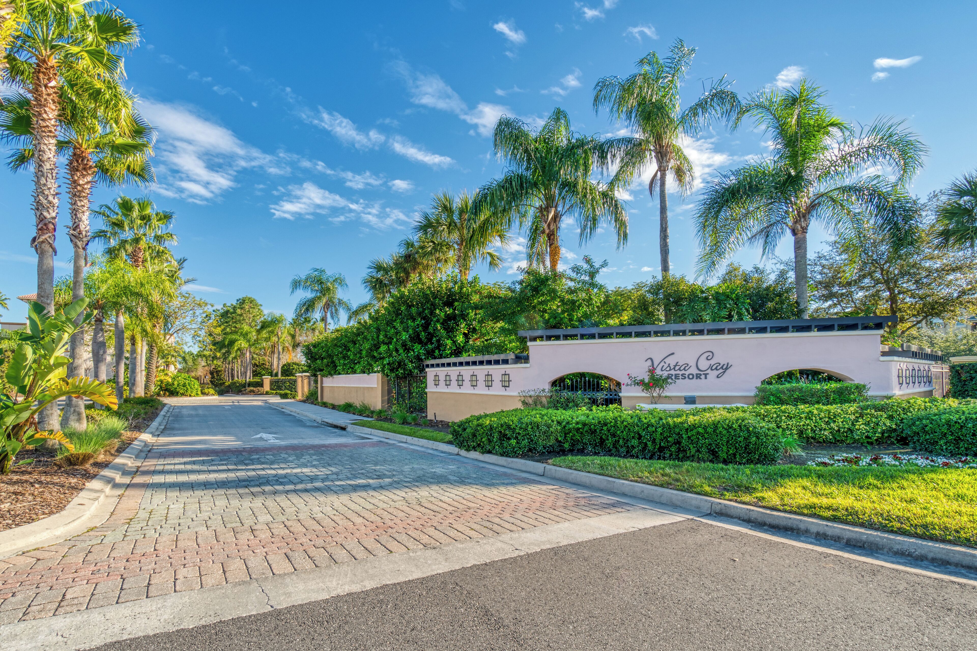 A paved pathway leading to a building with a sign reading "Vista Cay Resort."