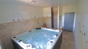 Un baño con una bañera grande, ducha e inodoro.