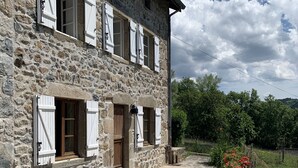 Un bâtiment en pierre doté de nombreuses fenêtres et d’une entrée pavée.