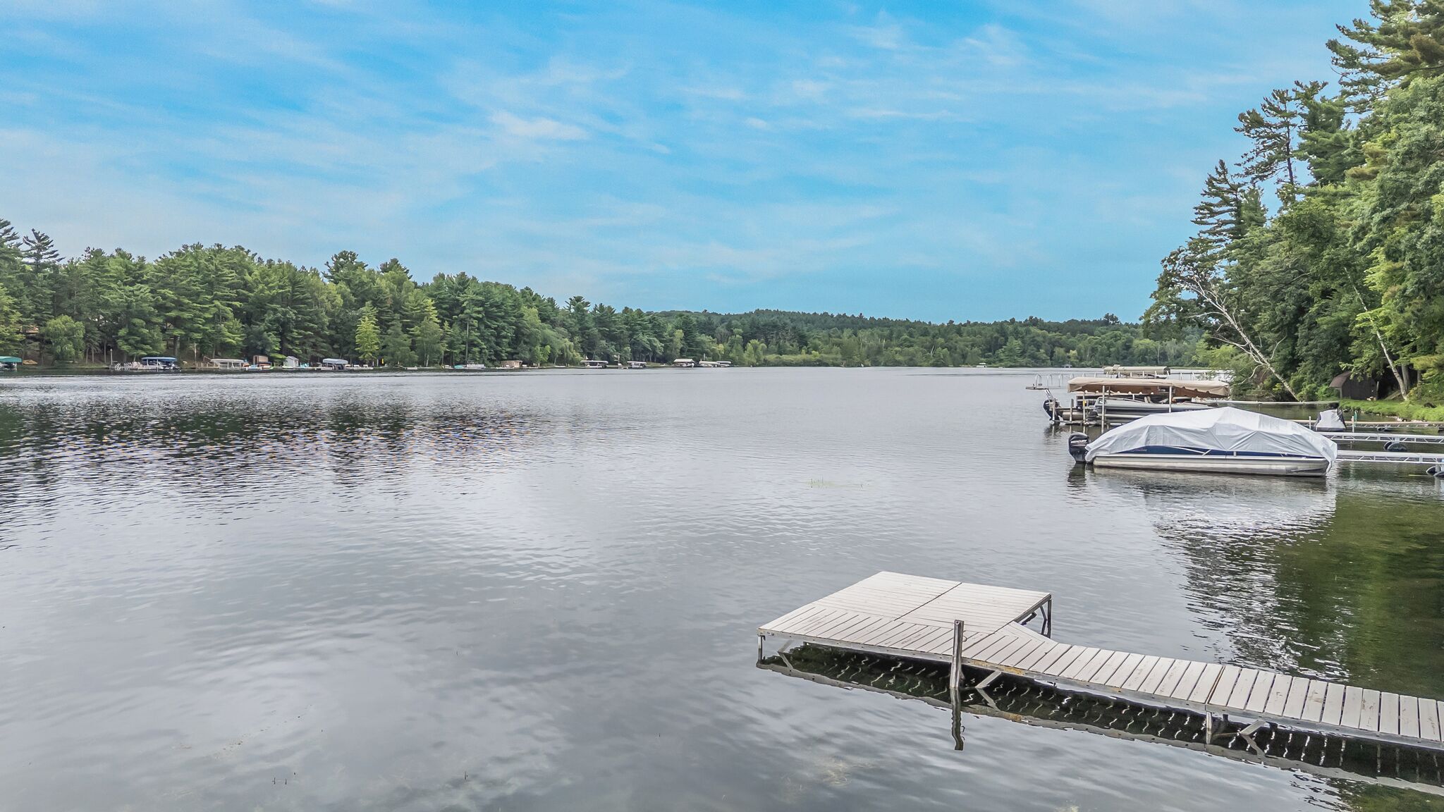 A calm lake with a wooden dock extending into the water.