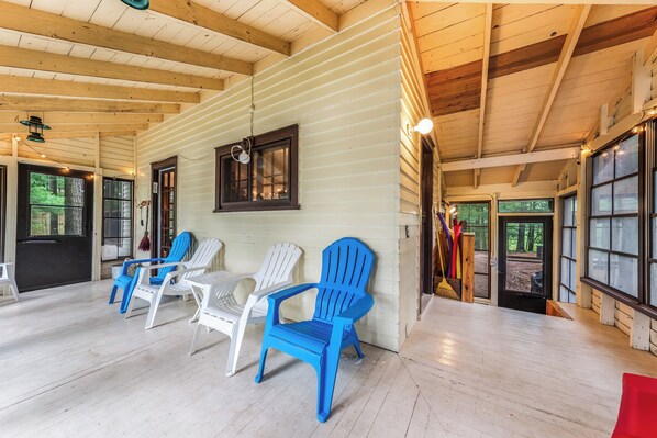 Un vaste espace intérieur doté de planchers et de murs en bois, aménagé avec plusieurs chaises en plastique bleues et blanches disposées pour accueillir les personnes.