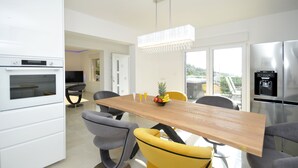 Una cocina moderna con una mesa de comedor de madera, sillas y un frutero.