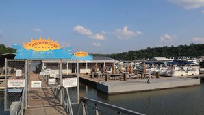 Un puerto deportivo con un muelle, barcos y un cartel que indica Taylorville Lake Marina.